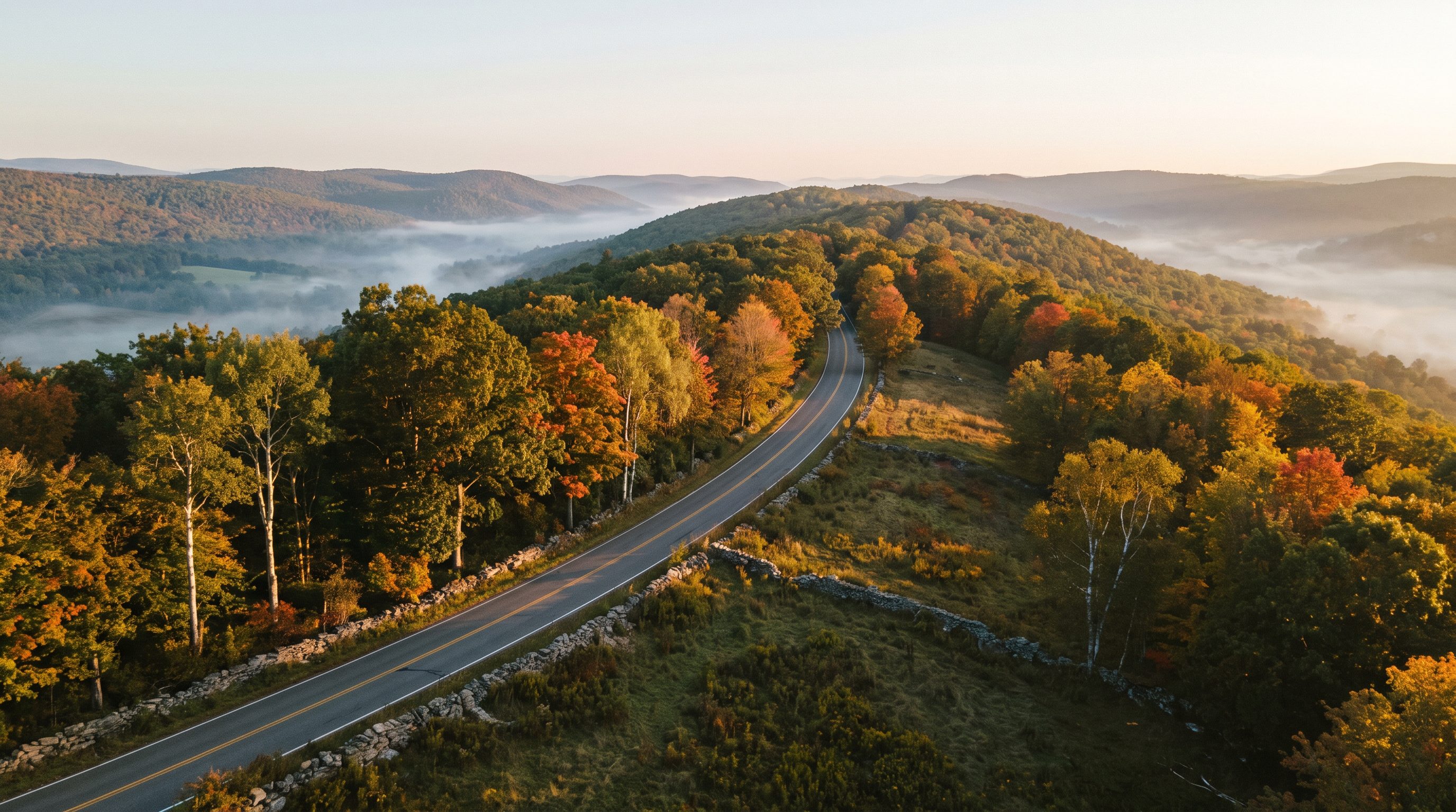 A rural two-lane road winding along a forested mountain ridge near Old Mountain Road in Mount Hope, New York